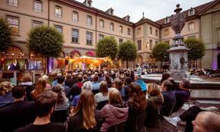 Im Innenhof des Berner Generationenhaus sitzt viel Publikum.